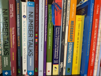 Stack of math-related books on a bookshelf