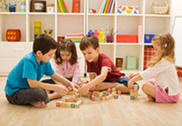 Kindergarten students playing with letter blocks