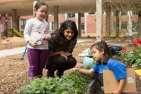 Two young student and teacher in a garden