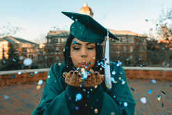 Graduating student blowing confetti 