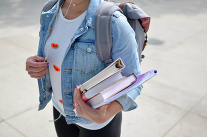 Photo of student with books in hand