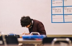 Student in classroom writing