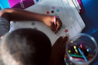 A child coloring on a sheet of paper