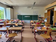 Empty classroom with books on top of desks