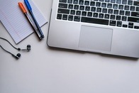Silver laptop computer beside white-ruled-paper