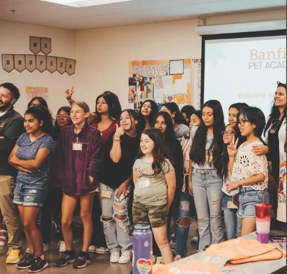 A large group of students stand together in a classroom