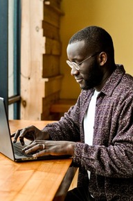 A person at table typing on a laptop