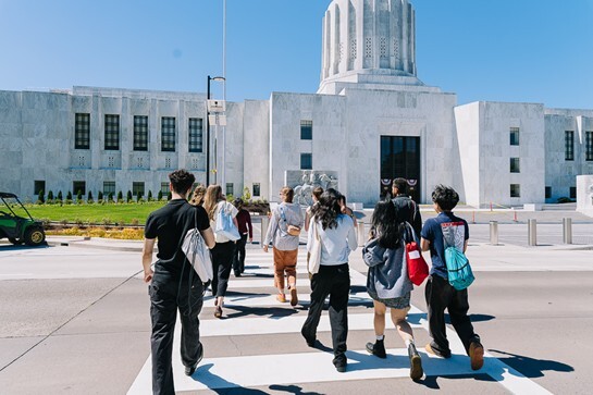 Students crossing the street in front of the Oregon capital building.