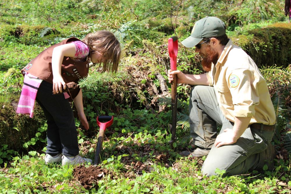 Forester and child planting a tree