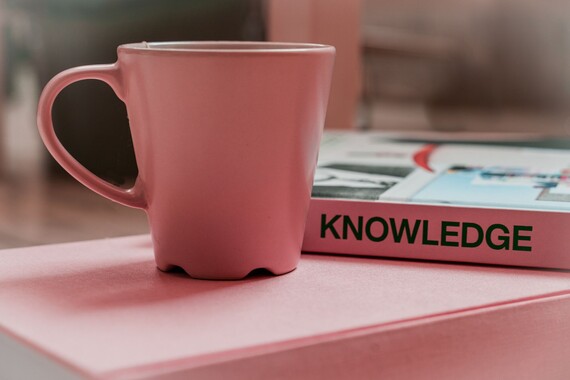 Pink reference book and pink coffee cup