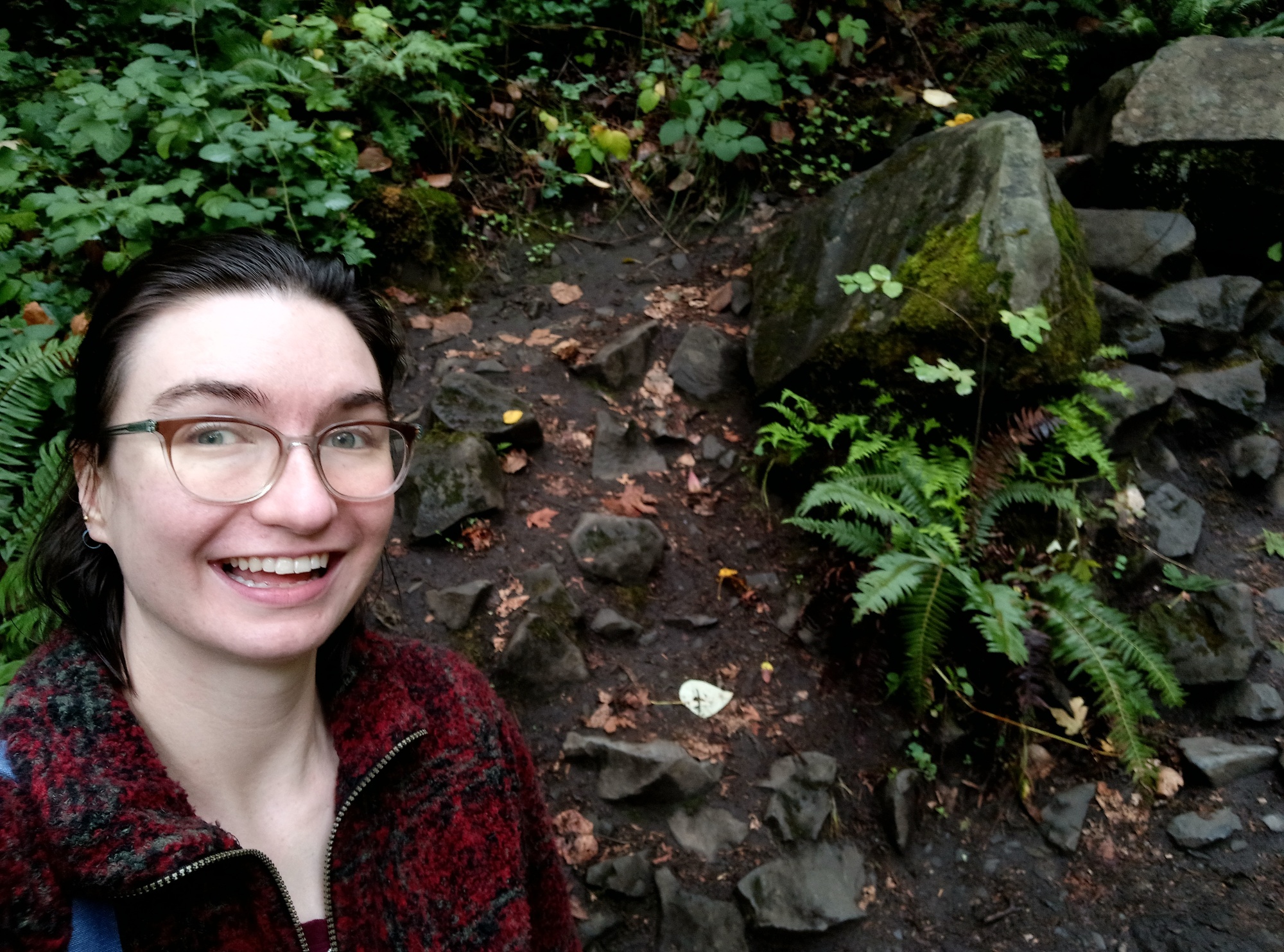 selfie of white woman with brown hair next to nature