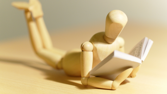 artists' figure mannequin reading tiny book