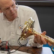 A man looking at the wiring in a house lamp