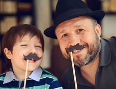 photo of man and young boy wearing fake mustaches