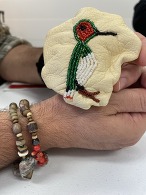 Matthew, an OSH patient, shows a beaded medicine bag with a hummingbird he created in a class offered by OSH Native Services.