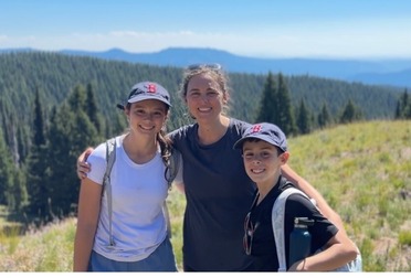 Dr. Bos with her two kids on a sunny hilltop
