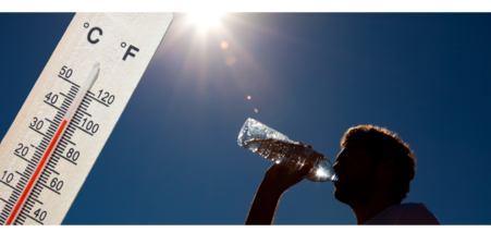 photo of a person drinking water in the hot sun with a thermometer showing 100 temp