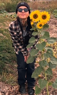 Xenia Carone, OSH peer support specialist, pictured with sunflowers