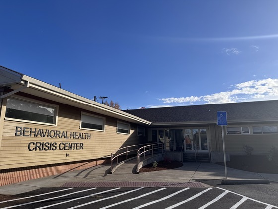 The outside of a beige building with a sign that says Behavioral Health Crisis Center