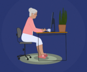 A woman with gray hair sitting in front of a computer at a desk.