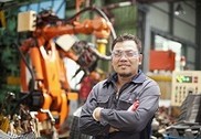 small photo - man in factory with robot