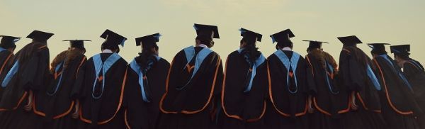 Line of college graduates facing away - small