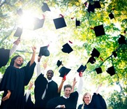 students surrounded by graduation caps