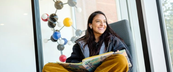 Student at Clackamas CCC with model of molecules beside her