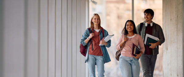 Stock image, 3 students walking in hallway