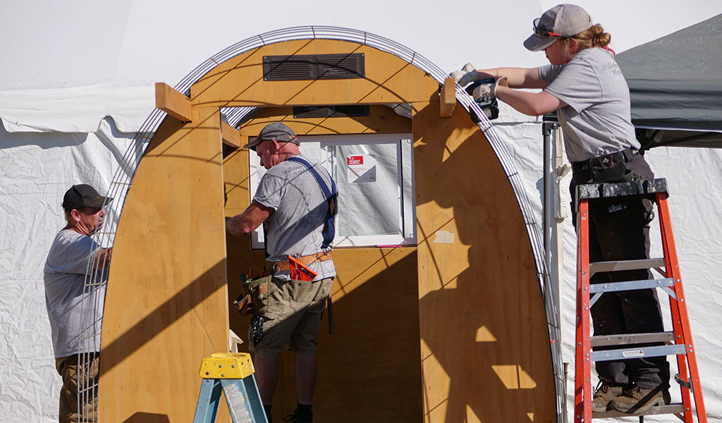 Members of the Hillsboro Handyman team install a roof on a Safe Rest Pod
