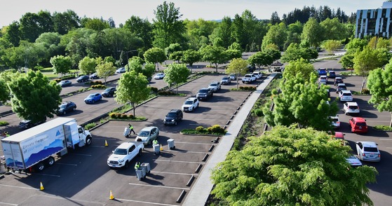 Drivers Lined Up in Their Vehicles and Dumping Sensitive Documents into Bins to be Shredded