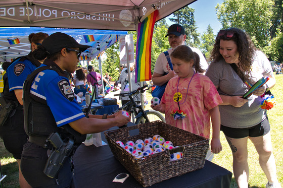 Two Officers in the Hillsboro Police Booth Talking to a Family with a Child