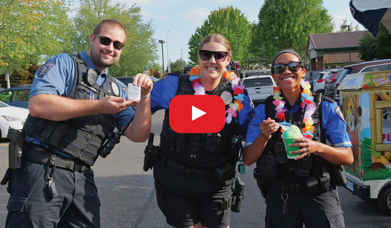 Two Police Officers Wearing Hawaiian Leis and a Code Compliance Officer with Sticker Badges
