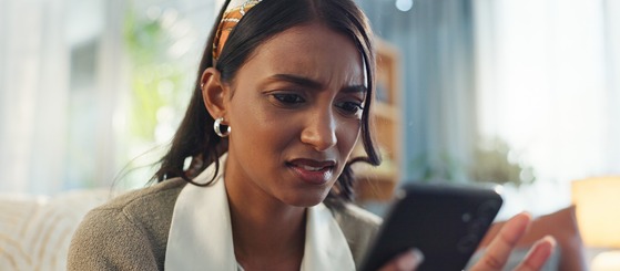 Woman Looking Frustrated at Her Cell Phone 