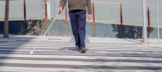 Man Crossing the Street with a White Cane