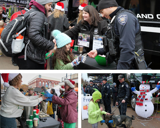Hillsboro Police handing out candy canes and hot cider, and a young child petting a police canine.