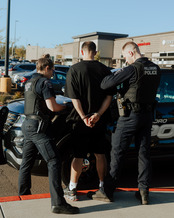 Two officers arresting a retail theft suspect