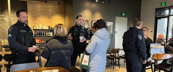 Three Hillsboro Police Officers talking with community members at a Starbucks