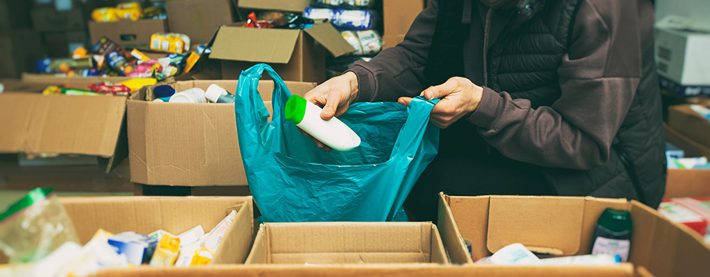 A person organizes donations of food, hygiene items, and warm clothing