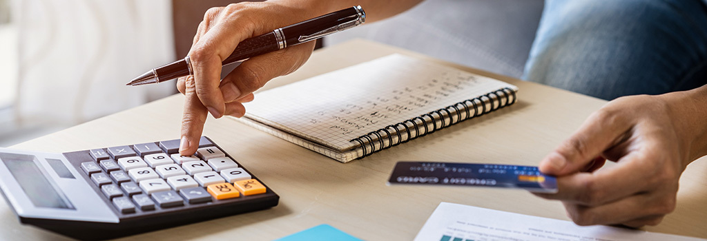 A person uses a calculator and pays bills