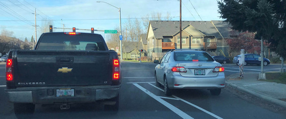 Two Vehicles at a Traffic Light - One of them is in the bike lane waiting to turn right