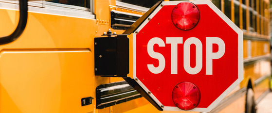 Side of a Yellow School Bus with a Flashing Stop Sign Extended Out
