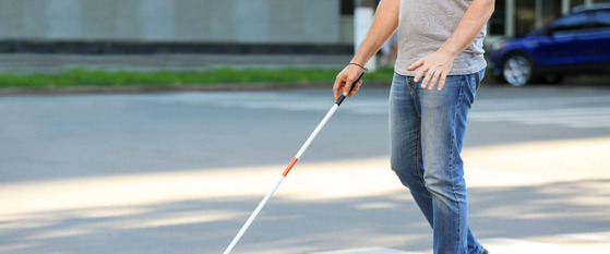 Person with a White Cane Walking Across a Street