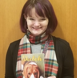 Rep. Mitchell holding the children's book, Shiloh.