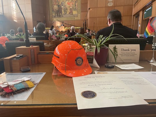 Hard hat and other items on rep nelon's desk