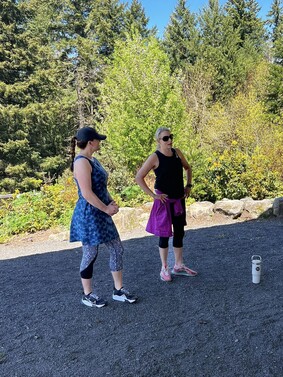 Senator Lieber and Representative Grayber stand outside, surrounded by trees, talking to a group