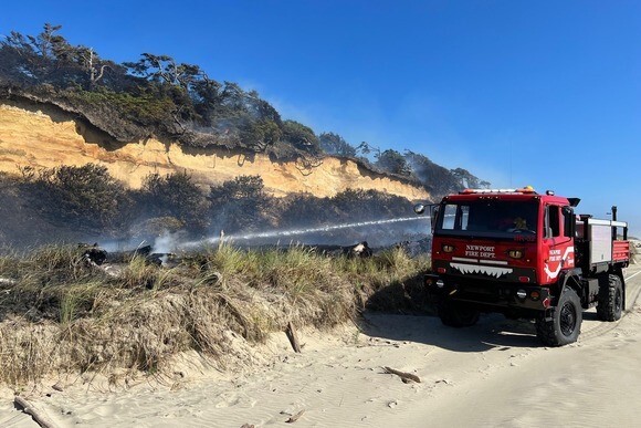 Newport Fire Department suppresses a grass fire on the beach 
