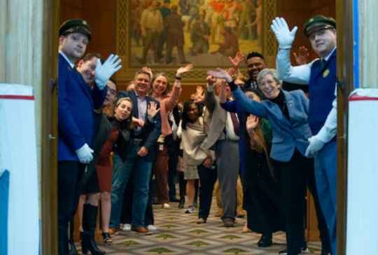 Rep Nelson and others wave down the chamber hall.