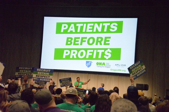 Rep Nelson speaking at ONA event with Profits Over Patients PowerPoint in background 