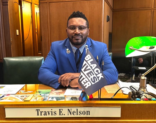 Rep Nelson sits at desk on the floor